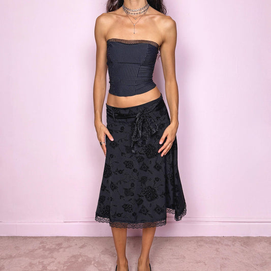 This vintage 2000s black jacquard brocade midi skirt features floral and paisley velvet details, lace trim at the hem, and a stretchy fit with side zipper closure. Made in Italy from a viscose polyester blend, it captures dark romance with a formal yet cute coquette allure. Ideal for office wear, elegant night parties, or refined events. Can be worn high/mid-rise for M size or low-rise for S size. Great vintage condition.