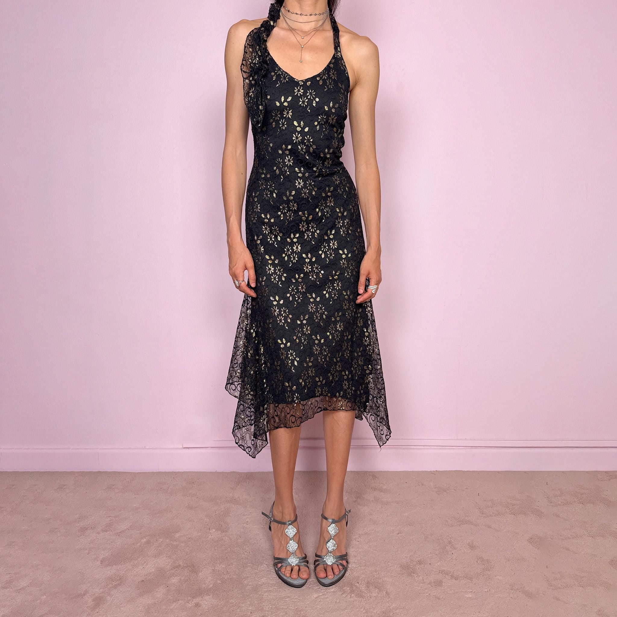 Vintage 2000s black backless halter midi dress with a V neckline, stretchy fit, asymmetric handkerchief hem, and lace mesh overlay with a gold floral pattern. Dark romantic statement piece for parties, nights out, or elegant evening events. Made by a Spanish designer. Excellent vintage condition.