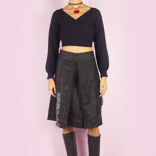 The Y2K Layered Black Midi Skirt features a unique design with contrasting text panels and raw hem details for an edgy and contemporary look. Its structured fit, midi length, low-rise waist, and back zipper closure make it perfect for casual evening looks.