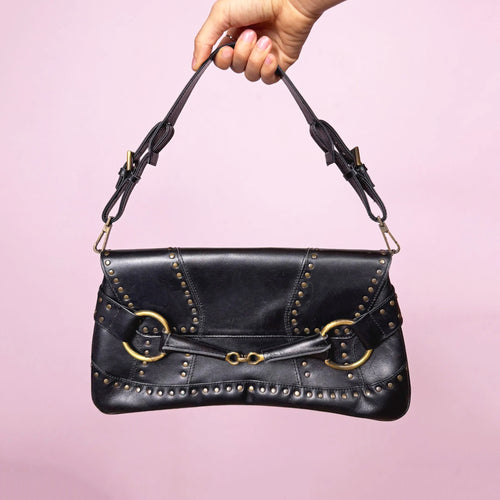 Stunning vintage early 2000s black studded shoulder bag by Lorenzo Coll. Genuine leather construction with bold Y2K silhouette, gold-tone brass hardware, large O-ring front details, adjustable strap, and magnetic snap button closure. Ideal for going out. Made in Spain. Excellent vintage condition.