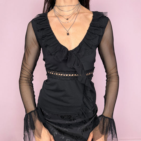 Vintage 2000s black fitted top with sheer mesh bell sleeves and flared cuffs. Features a deep ruffle neckline, asymmetric cascading ruffle front, and delicate lace panel under the bust. Feminine yet witchy dark goth evening style. Made in France. Excellent vintage condition.