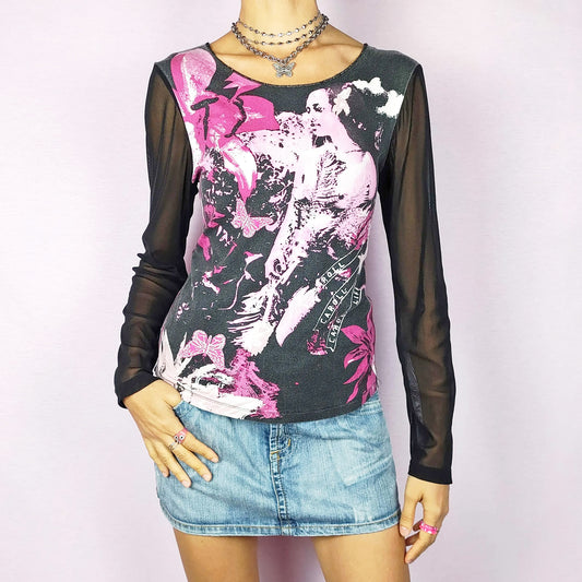 The Y2K Black Print Mesh Top is a vintage 2000s stretchy piece featuring a pink and white graphic print across the front and sheer black mesh long sleeves. Perfect for casual wear or dressing up for a night out.