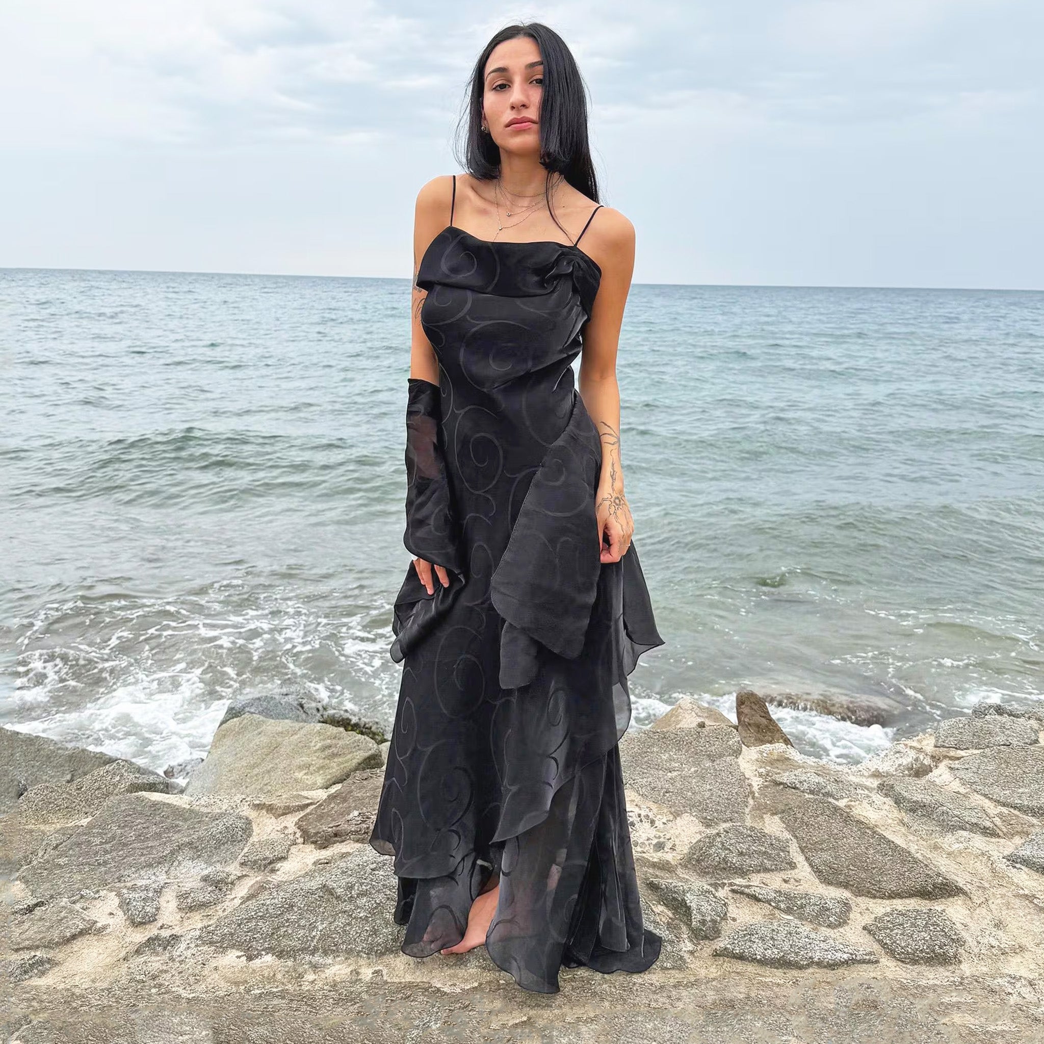 Vintage 2000s black organza-style layered slip midi dress with a swirl pattern, folded neckline, spaghetti straps, side zipper, and flowing asymmetrical hem. Comes with a matching scarf, ideal for galas, proms, or dark romantic nights. Made by a French brand from a non-stretch polyester blend. Excellent vintage condition.