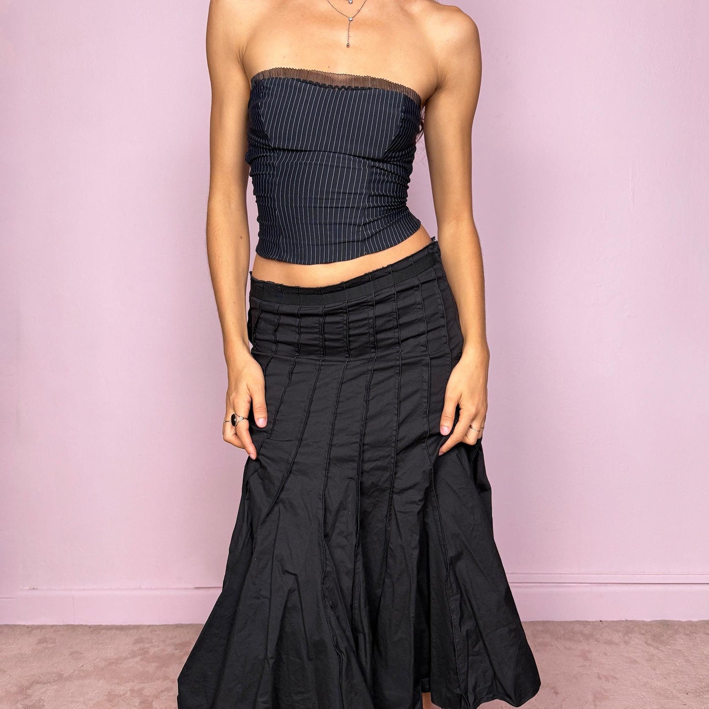 This vintage 2000s black paneled midi skirt features a structured godet flare hem and side zipper closure. Slightly stretchy with a refined drape, it can be worn high-rise for size S or mid-rise for size XS. A stunning French-made piece ideal for formal nights, office wear, or elegant parties. Made in France from a cotton lycra blend. Excellent vintage condition.