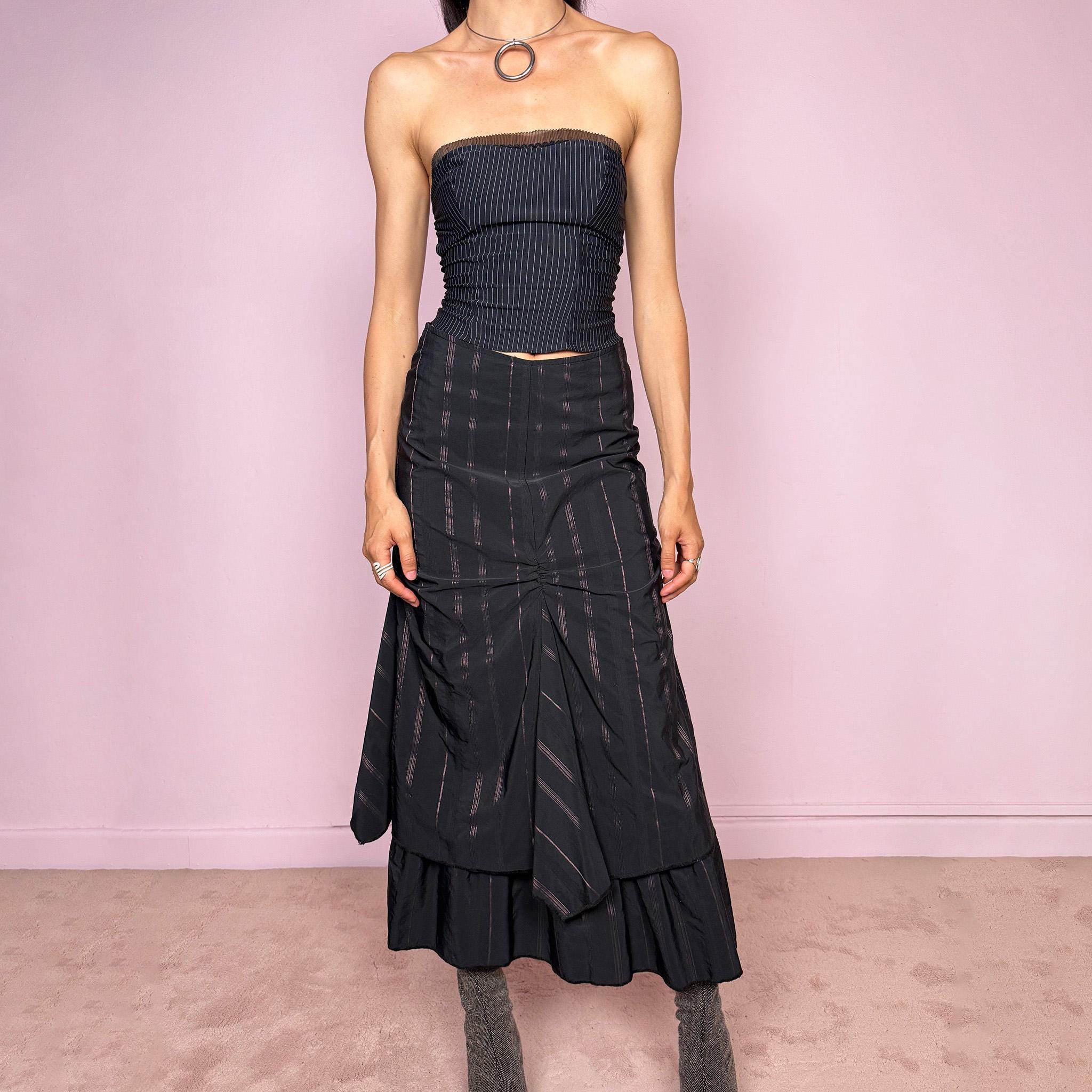 Vintage 2000s black midi skirt with pink pinstripes, a layered deconstructed silhouette, ruched details, and ruffled hem. This dark avant-garde piece has a structured no-stretch fit with back zip closure. Can be worn high waisted for size S or lower rise for XXS and XS. Made in France from a cotton, polyamide, and polyester blend. Great vintage condition.