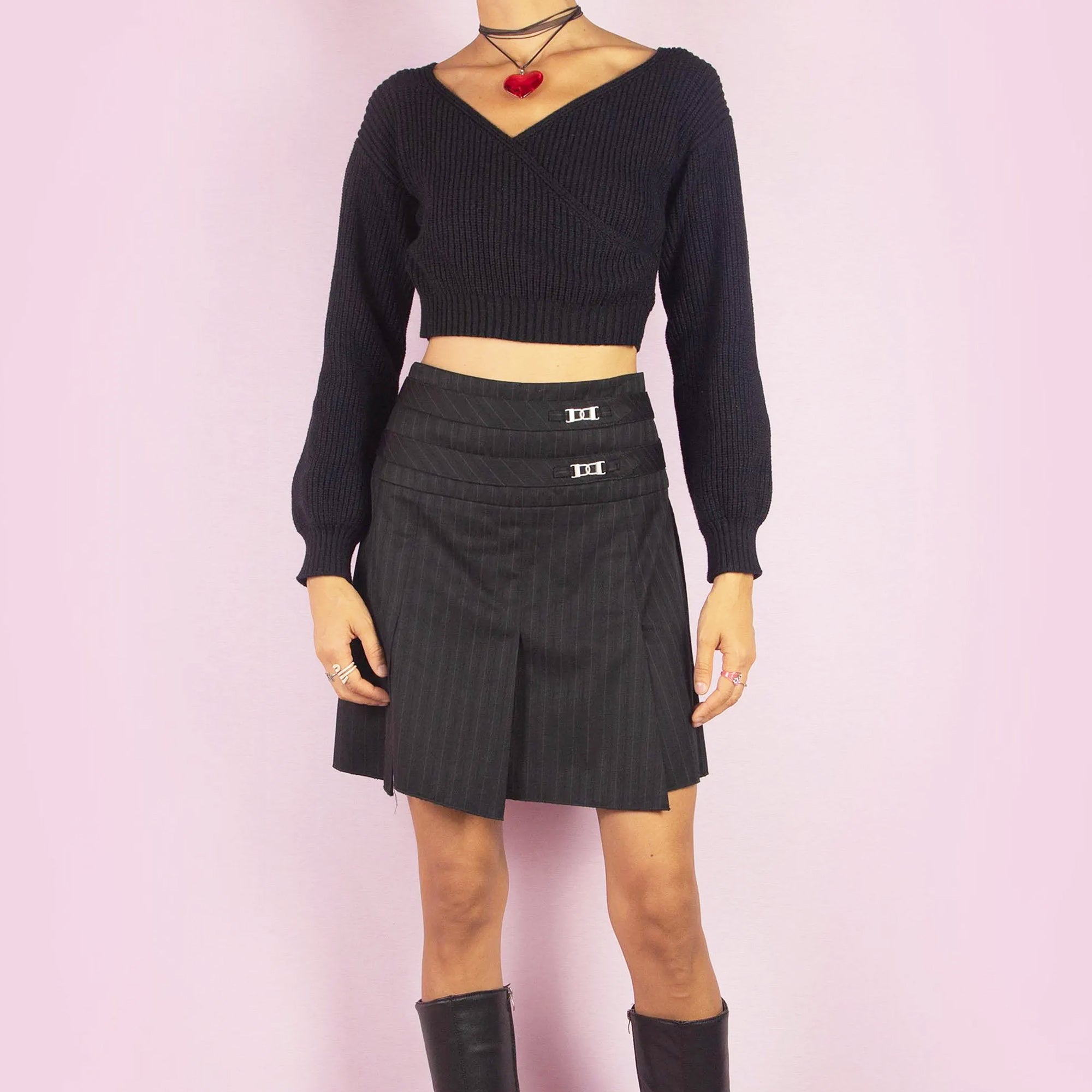 The Y2K Pinstripe Pleated Mini Skirt is a vintage 2000s piece featuring a classic pinstripe pattern with pleated detailing in black. Designed with a mid-rise fit, mini length, and side zipper closure, it’s perfect for office-to-evening transitions or casual chic outfits.