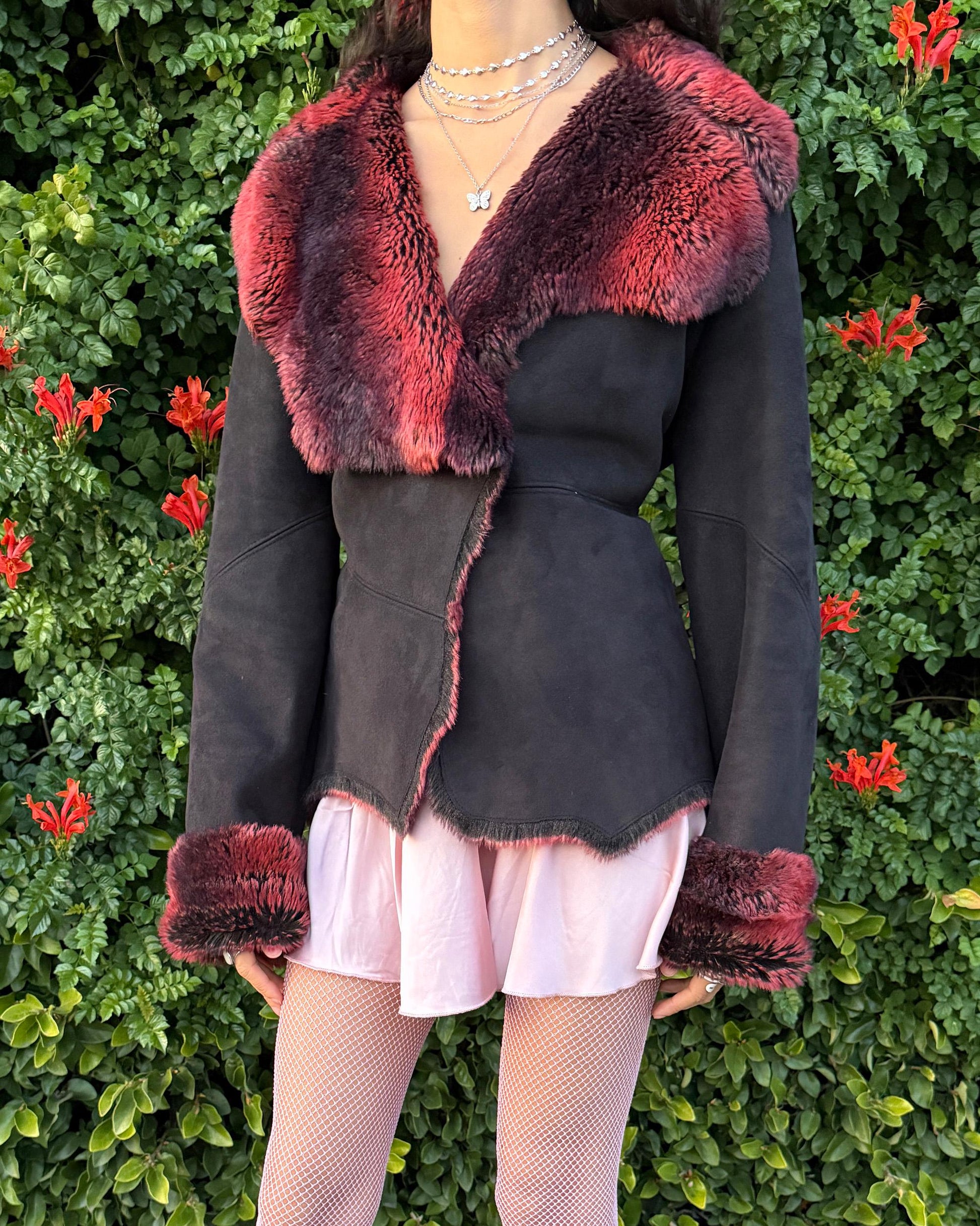 Stunning vintage 2000s Penny Lane–style jacket featuring a black faux-suede exterior with full red-and-black faux-fur lining. Designed with a dramatic faux-fur trimmed collar and cuffs, angled panel construction and a single button closure for a fitted silhouette. The polyester–acrylic blend has no stretch and provides a warm, cozy feel ideal for winter layering. A French-design cyber streetwear and grunge statement coat perfect for night outings and bold Y2K styling.