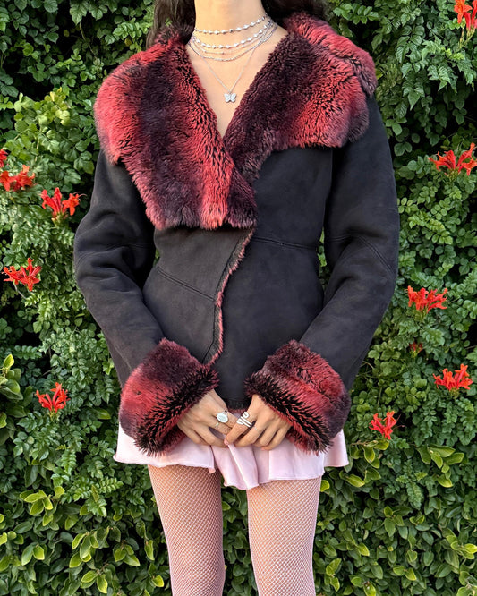 Stunning vintage 2000s Penny Lane–style jacket featuring a black faux-suede exterior with full red-and-black faux-fur lining. Designed with a dramatic faux-fur trimmed collar and cuffs, angled panel construction and a single button closure for a fitted silhouette. The polyester–acrylic blend has no stretch and provides a warm, cozy feel ideal for winter layering. A French-design cyber streetwear and grunge statement coat perfect for night outings and bold Y2K styling.