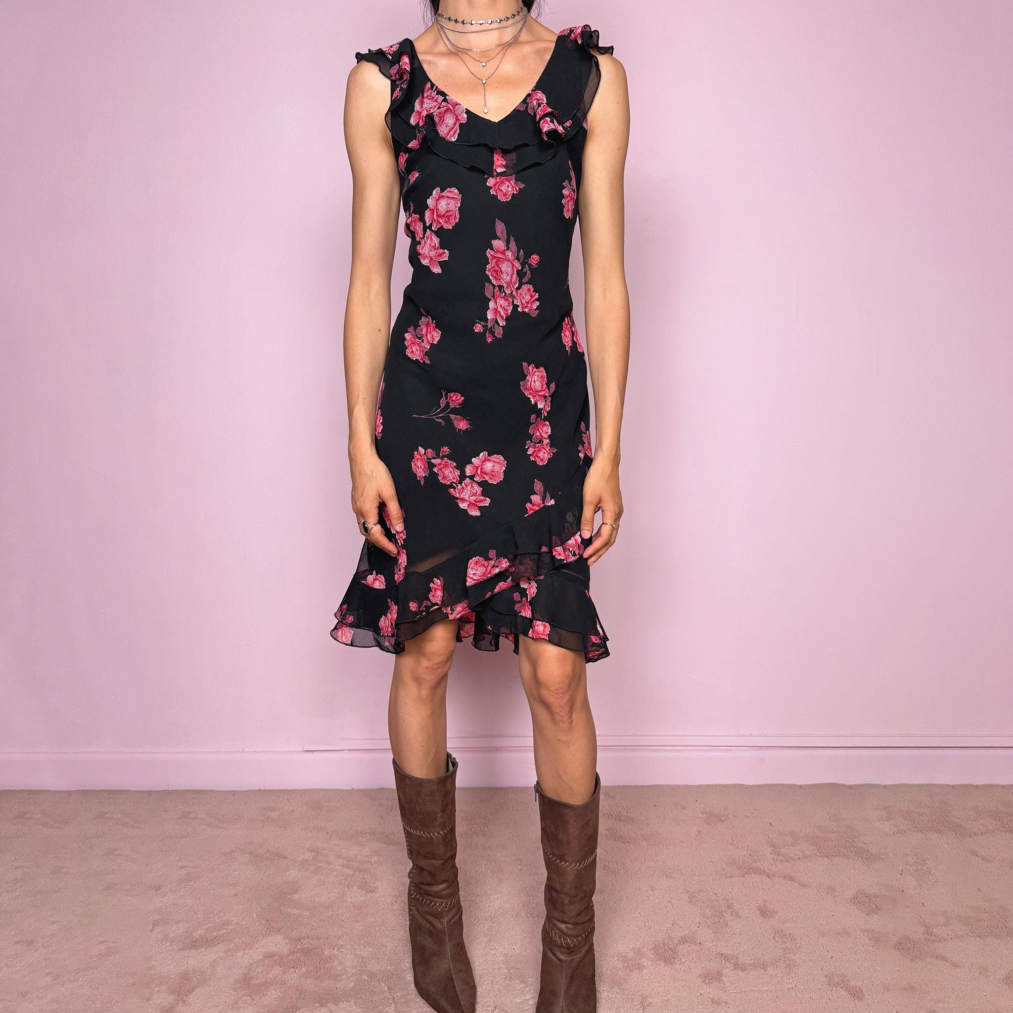 Vintage 2000s black floral mini dress with a romantic 90s feel, pink rose print, sleeveless fitted silhouette, V neckline, ruffled bust and straps, and an asymmetric layered ruffle tulip hem. Ideal for feminine spring and summer looks. Made by a French brand. Great vintage condition.
