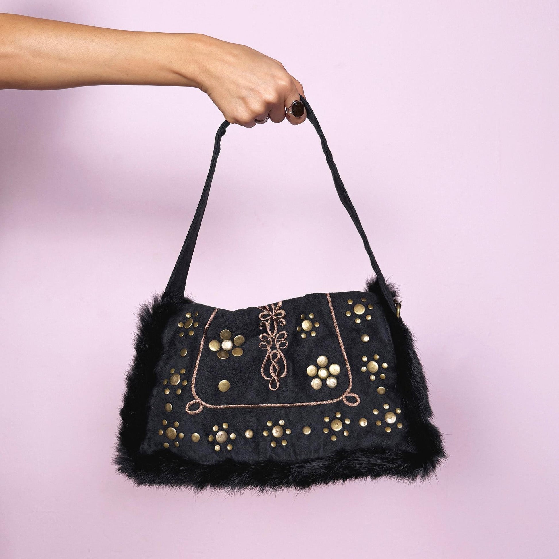 Vintage 2000s dark gray-almost-black shoulder bag featuring soft faux suede and corduroy with black faux fur trim along the flap. The front showcases golden round studded details and brown embroidered accents for a bold boho look. It has a zipper closure and a comfortable shoulder strap, making it a super cute party or night-out statement piece. Designed in France. Excellent vintage condition.