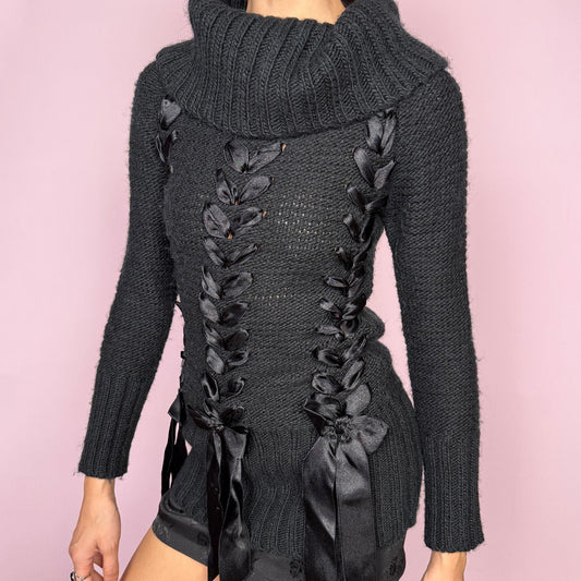 Dark coquette vintage 2000s black turtleneck chunky knit sweater with long sleeves. Features lace-up satin-style ribbon details creating a romantic, unique statement design. Soft yet structured with a fitted silhouette, perfect for winter layering or styled as a standout piece. Stretchy 60% acrylic and 40% wool blend made by a French brand. Great vintage condition.