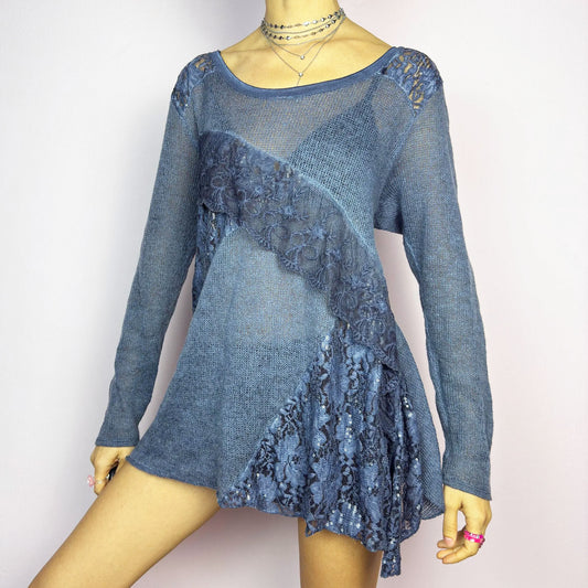 The Y2K Blue Lace Asymmetric Sweater is a vintage 2000s piece featuring a semi-sheer knit design with delicate lace and sequin paneling in an asymmetrical pattern. Designed with a scoop neckline, long sleeves, and a flowy silhouette, this sweater tunic adds a dreamy, romantic touch to any outfit. Perfect for layering in autumn and winter.