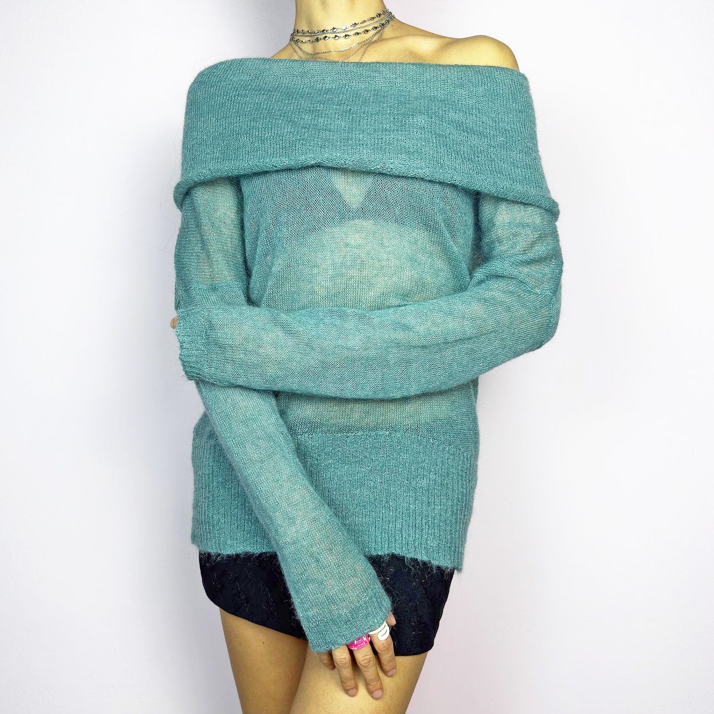 The Y2K Blue Off-Shoulder Sweater is a vintage 2000s cozy and comfy piece made from a mohair, wool, and nylon blend. This soft, semi-sheer sweater features a folded off-shoulder neckline and a muted blue hue. Perfect for creating elegant yet casual outfits, ideal for layering or wearing on its own for a chic, understated look. Excellent vintage condition.