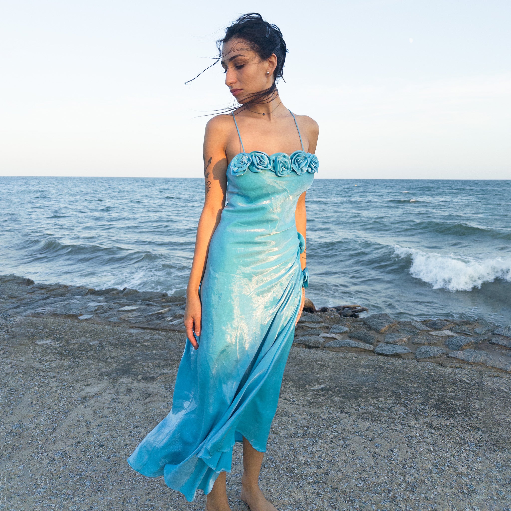 Vintage 2000s blue slip dress, a French-made fantasy with sculptural rosette appliqué along the bust and ruched side detail. Iridescent shimmer finish, fluid midi length and elegant slip silhouette create dreamy movement. Perfect for proms, summer weddings or romantic evenings. Made in France from a shimmering non-stretch fabric. Great vintage condition.