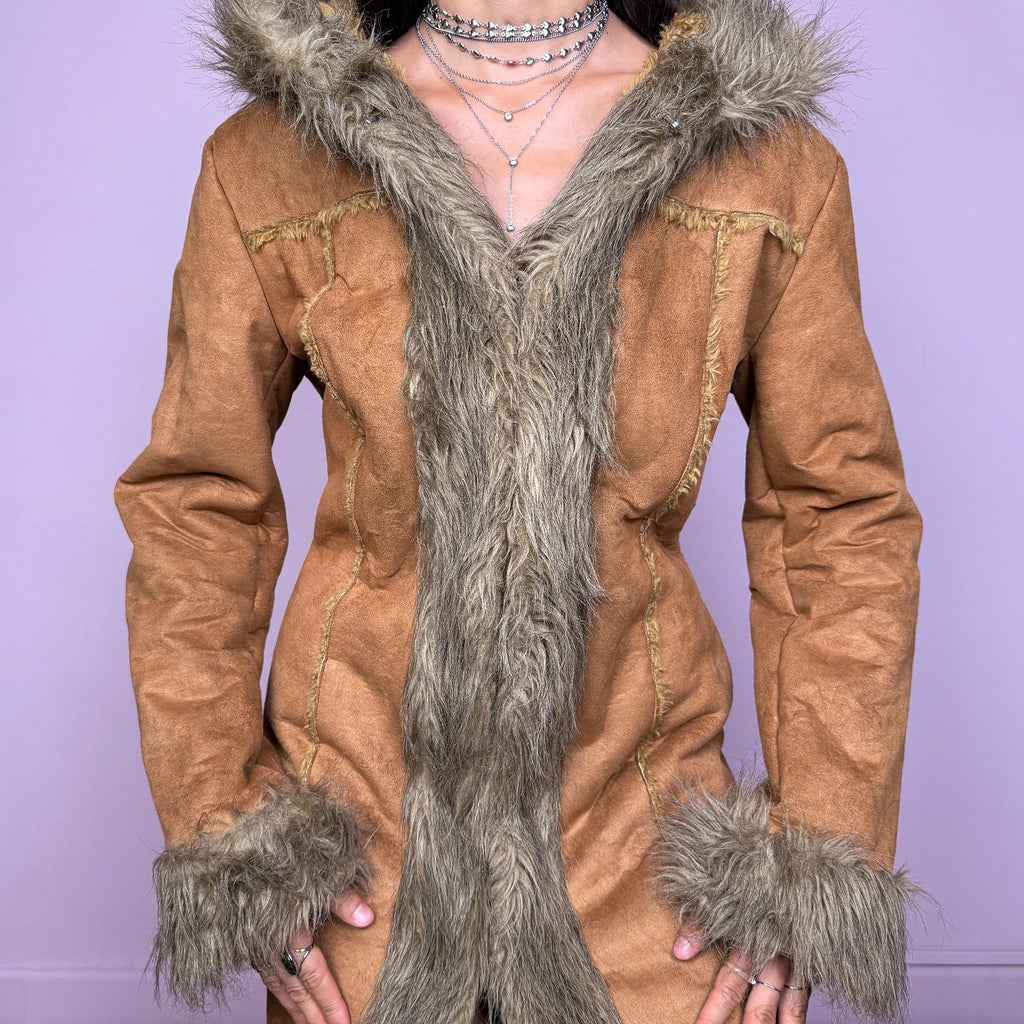 This vintage 2000s brown faux suede long coat features a hooded Afghan Penny Lane silhouette with plush beige faux fur trim and cuffs. Fitted through the body with hidden hook closure and side pockets, it delivers a warm, bohemian look perfect for autumn and winter layering. Made from faux suede with faux fur lining. Great vintage condition.