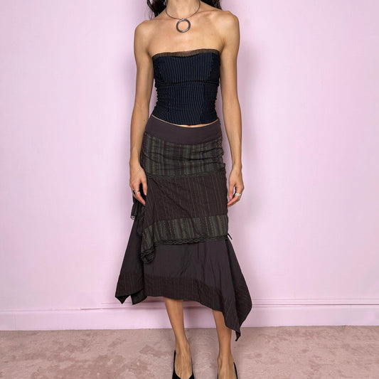 Vintage 2000s dark brown asymmetric midi skirt with an avant garde deconstructed layered design, featuring striped panels with subtle green lines, lace trim, and tie drawstring side details. Side zipper closure with no stretch. Fairy grunge aesthetic. Can be worn high waisted for size S or worn lower on the waist for size XS/XXS. Made by a French brand from a cotton polyester polyamide blend. Great vintage condition.