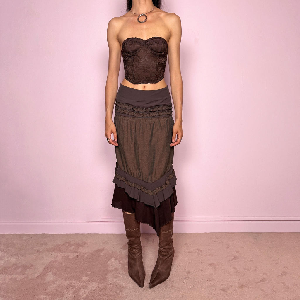 Vintage 2000s brown asymmetric skirt featuring an asymmetric mesh hem, side zip closure, no stretch, layered draped panels, and ruffle trim detailing throughout the waist and hem. Designed in a dark earthy brown tone with a romantic bohemian Y2K feel, perfect for fairy autumn looks. Can be worn high-waisted for size S or lower rise for XS. Made by a French brand. Excellent vintage condition.