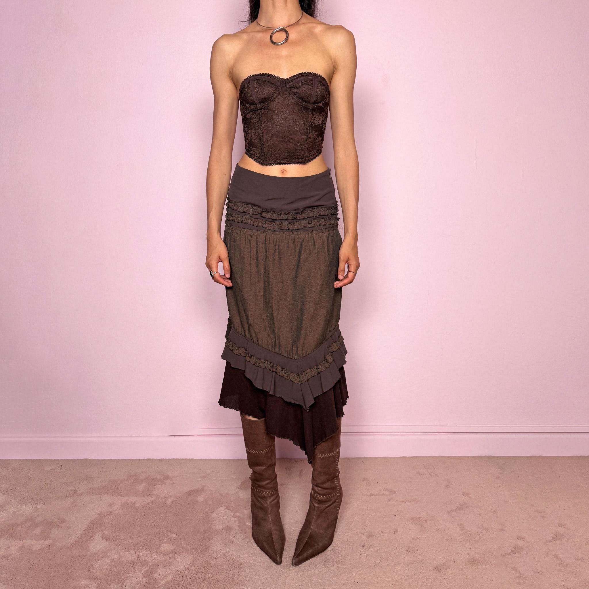 Vintage 2000s brown asymmetric skirt featuring an asymmetric mesh hem, side zip closure, no stretch, layered draped panels, and ruffle trim detailing throughout the waist and hem. Designed in a dark earthy brown tone with a romantic bohemian Y2K feel, perfect for fairy autumn looks. Can be worn high-waisted for size S or lower rise for XS. Made by a French brand. Excellent vintage condition.