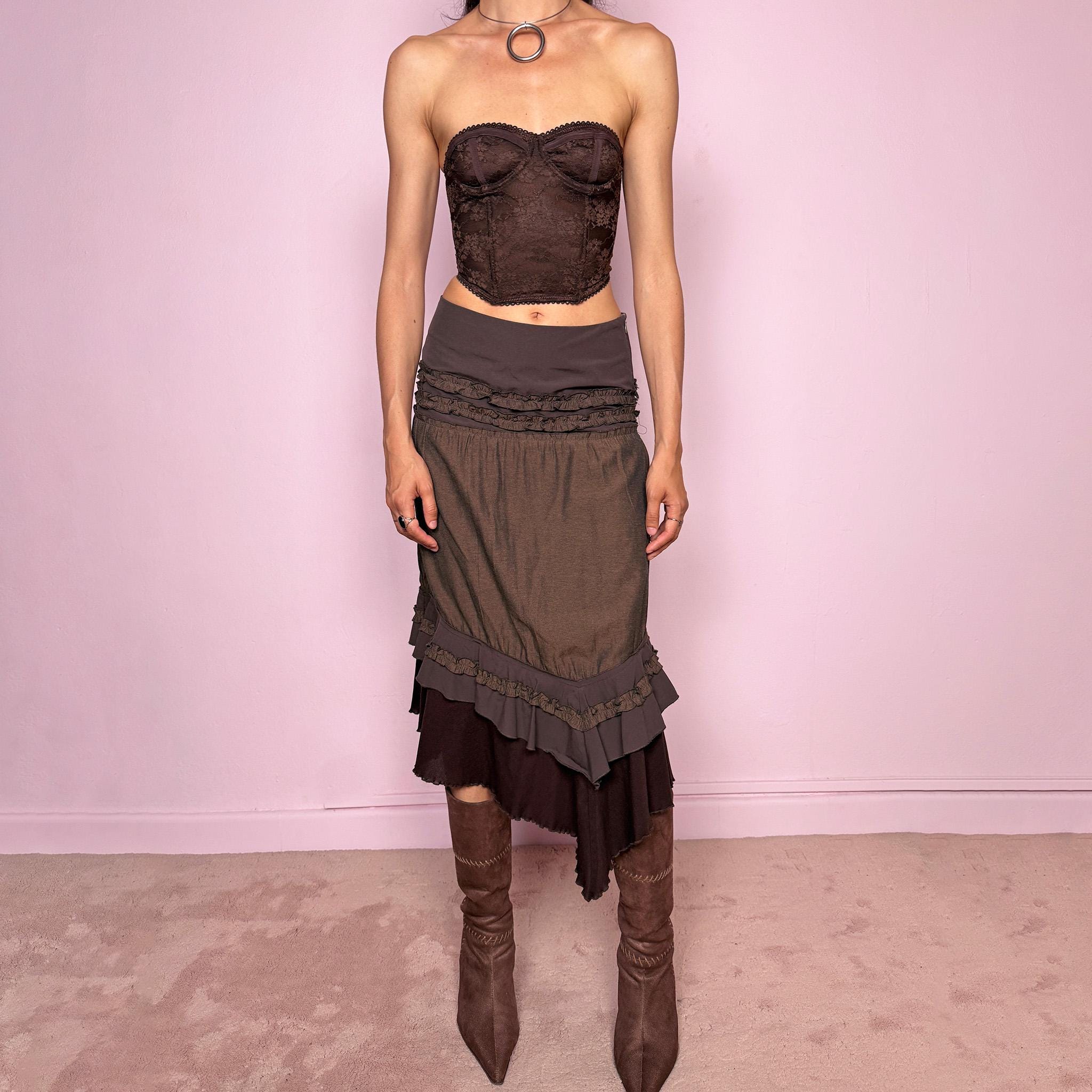 Vintage 2000s brown asymmetric skirt featuring an asymmetric mesh hem, side zip closure, no stretch, layered draped panels, and ruffle trim detailing throughout the waist and hem. Designed in a dark earthy brown tone with a romantic bohemian Y2K feel, perfect for fairy autumn looks. Can be worn high-waisted for size S or lower rise for XS. Made by a French brand. Excellent vintage condition.
