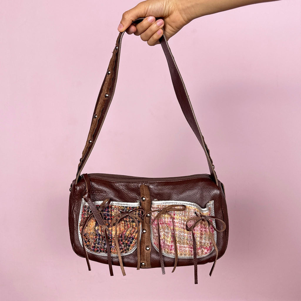 Vintage 2000s genuine leather shoulder bag made in Italy by Cromia, crafted in rich brown leather with textured woven panel details, delicate tie ribbon accents, and studded details. Features a structured baguette silhouette with zip closure and artisanal finishes, blending boho romantic and fairycore aesthetics. Great vintage condition.