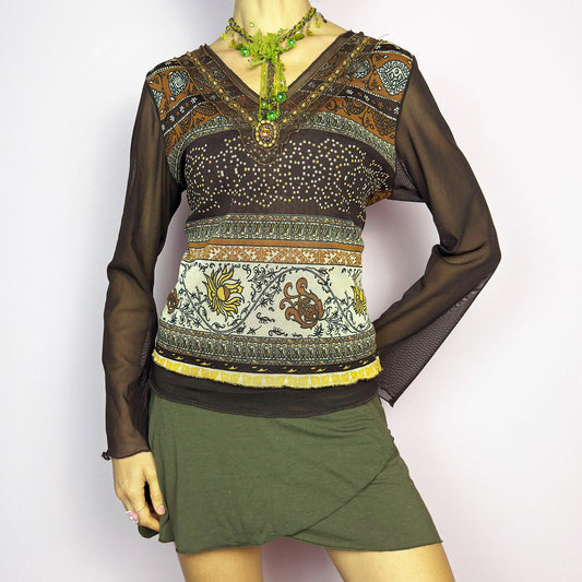 The Y2K Brown Bell Sleeve Mesh Top is a vintage 2000s piece featuring a semi-sheer mesh fabric with baroque and floral-inspired prints. Designed with flared bell sleeves, a fitted silhouette, and a layered hem, this top embodies a dreamy bohemian aesthetic. The lightweight and stretchy fabric make it perfect for ethereal, fairy-grunge looks. Excellent vintage condition.