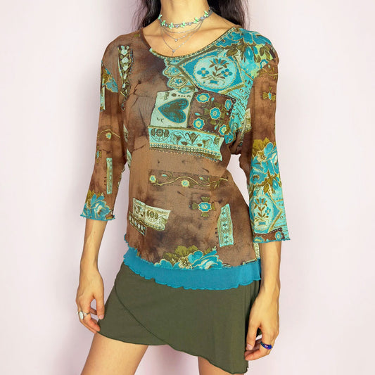 This vintage 2000s mesh top features a patchwork-style floral print in turquoise, blue, olive, and brown on a semi-sheer base. Designed with three-quarter sleeves, a wide scoop neckline, and lettuce trim at the hem and cuffs, it carries an artistic bohemian flair. A whimsical, rare Y2K piece with luminous color and light texture, ideal for casual summer days and playful layering. Made of polyamide. Excellent vintage condition.