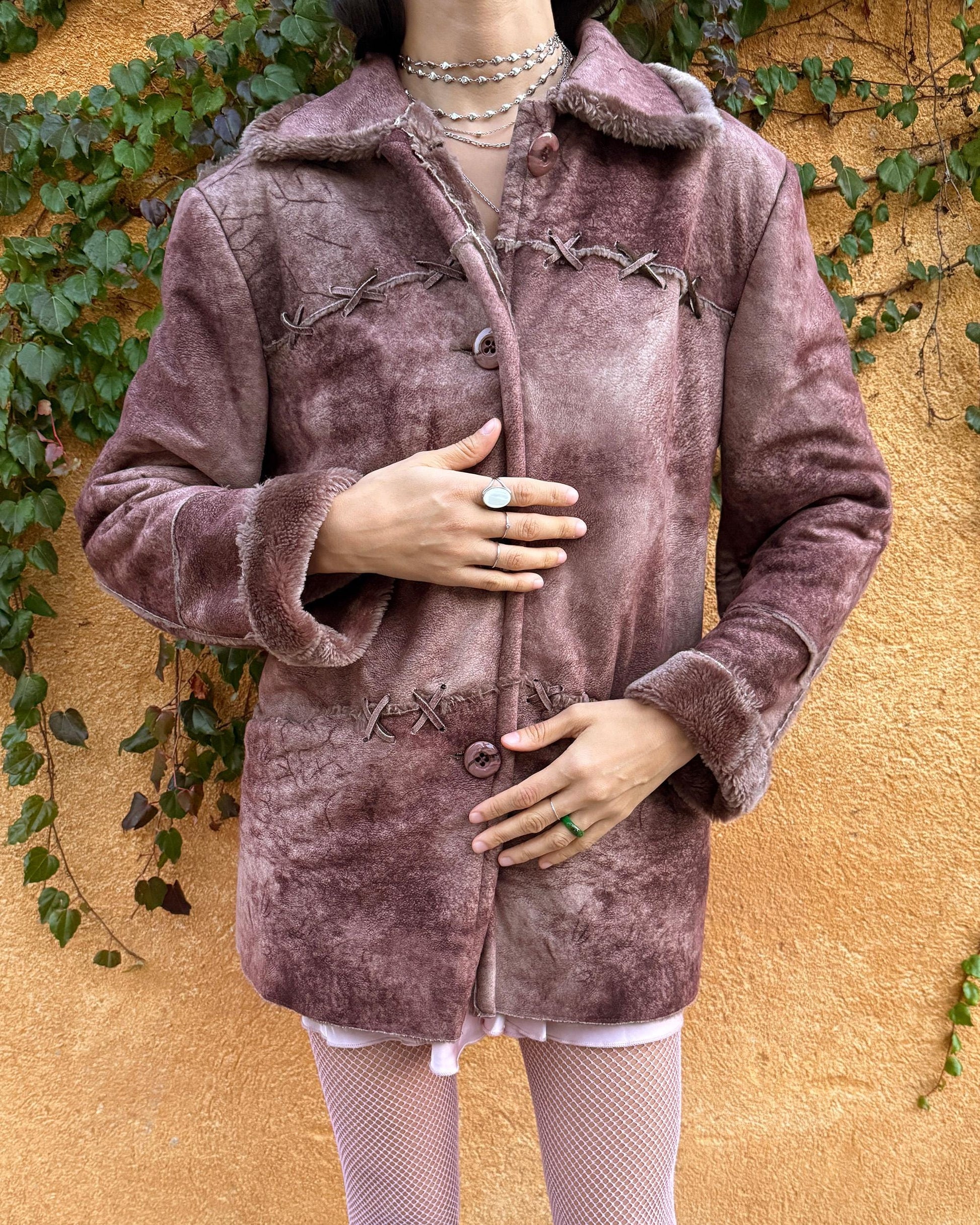 Vintage 2000s faux shearling coat in a rare reddish-brown (terracotta) tie-dye distressed finish. Features a faux fur collar and cuffs, button closure, side pockets, and decorative criss-cross stitch detailing for a dystopic cyber-grunge aesthetic. The straight silhouette makes it ideal for winter layering and festival styling. A standout 2000s piece for streetwear, weird-girl outfits, and bold cold-weather looks. Made from a polyester acrylic blend. Great vintage condition.