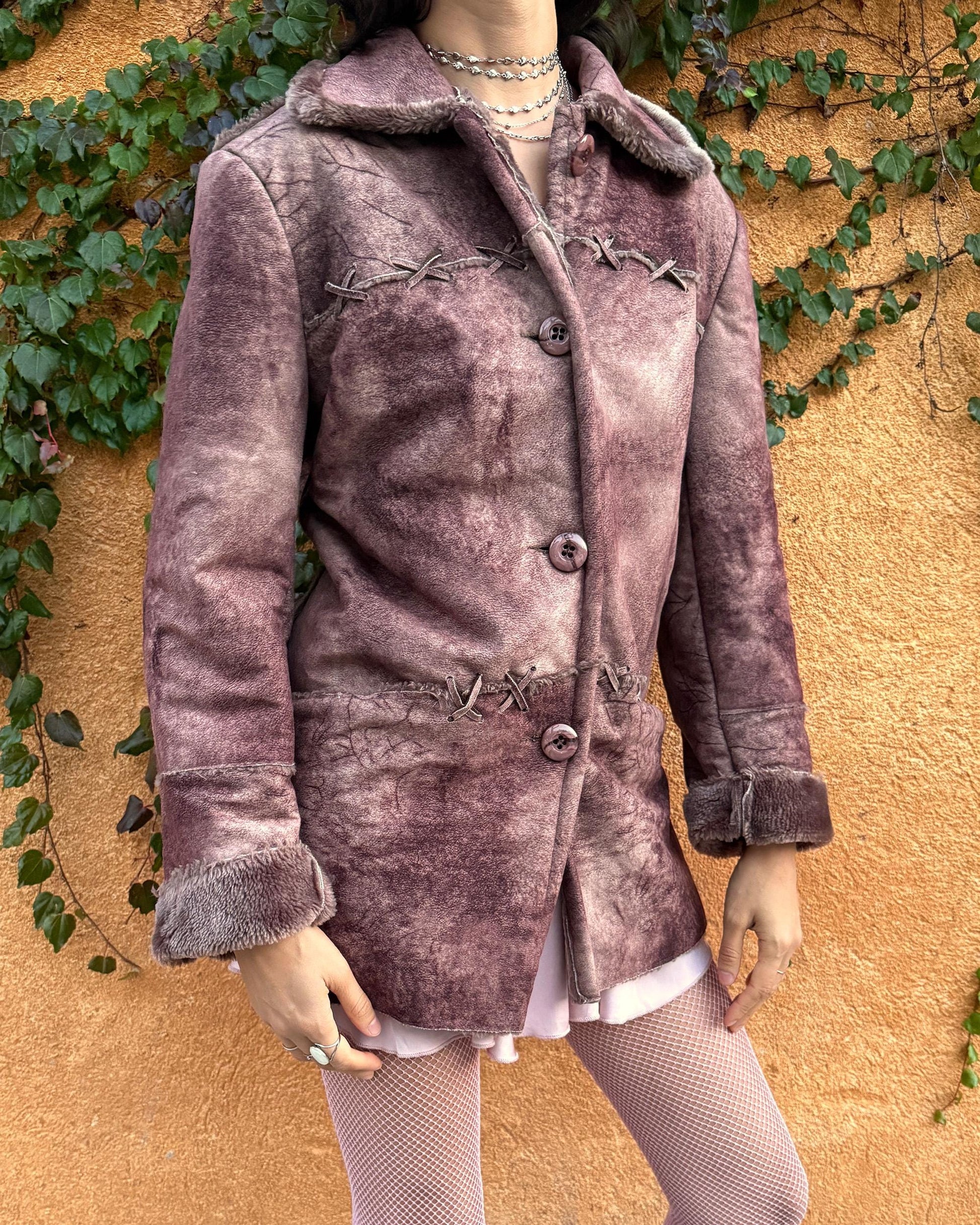 Vintage 2000s faux shearling coat in a rare reddish-brown (terracotta) tie-dye distressed finish. Features a faux fur collar and cuffs, button closure, side pockets, and decorative criss-cross stitch detailing for a dystopic cyber-grunge aesthetic. The straight silhouette makes it ideal for winter layering and festival styling. A standout 2000s piece for streetwear, weird-girl outfits, and bold cold-weather looks. Made from a polyester acrylic blend. Great vintage condition.