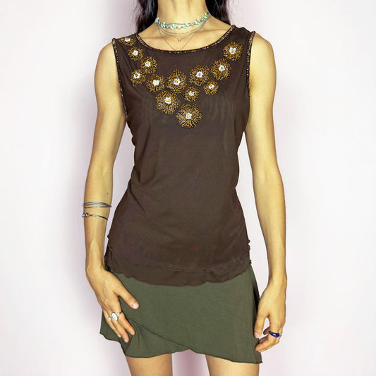 This vintage 2000s mesh top by Jobis was made in Germany and features intricate gold and crystal beading in floral formations across the chest. Rendered in rich brown with a sleeveless cut and a slightly sheer, body-hugging silhouette. A rare evening piece with strong Y2K glam energy, perfect for formal settings, night parties, and elegant events. Made of polyamide blend. Excellent vintage condition.