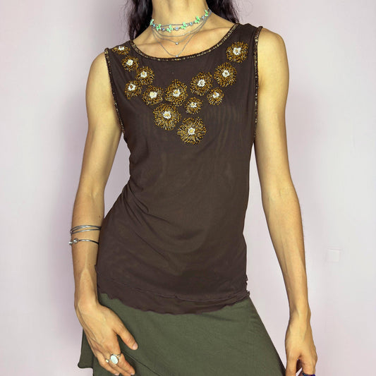 This vintage 2000s mesh top by Jobis was made in Germany and features intricate gold and crystal beading in floral formations across the chest. Rendered in rich brown with a sleeveless cut and a slightly sheer, body-hugging silhouette. A rare evening piece with strong Y2K glam energy—perfect for formal settings, night parties, and elegant events. Made of polyamide blend. Excellent vintage condition.