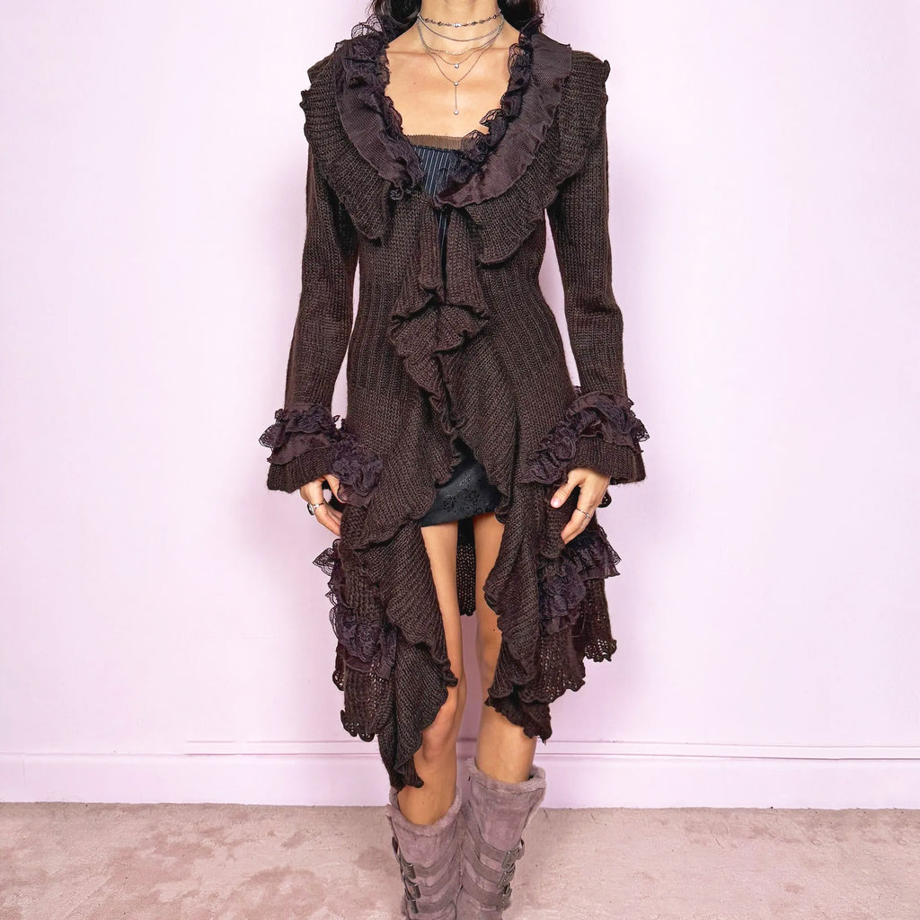 Vintage 2000s romantic dark brown longline cardigan with dramatic ruffle neckline and lace details. Features bell sleeves with ruffle cuffs, toggle front closure and an asymmetric pointy hem. Whimsical fairycore silhouette with dark baroque rococo energy, perfect for cozy winter layering. Made from a 35% mohair and 45% acrylic blend. Excellent vintage condition.