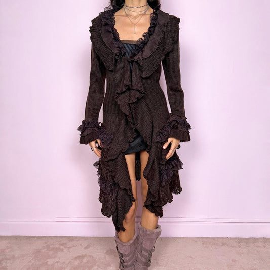 Romantic vintage 2000s dark brown longline cardigan with dramatic ruffle neckline and lace details. Features bell sleeves with ruffle cuffs, toggle front closure, and asymmetric pointy hem. Whimsical fairycore silhouette with dark baroque rococo style. Stretchy fabric for cozy winter layering. Made from acrylic mohair wool blend. Excellent vintage condition.