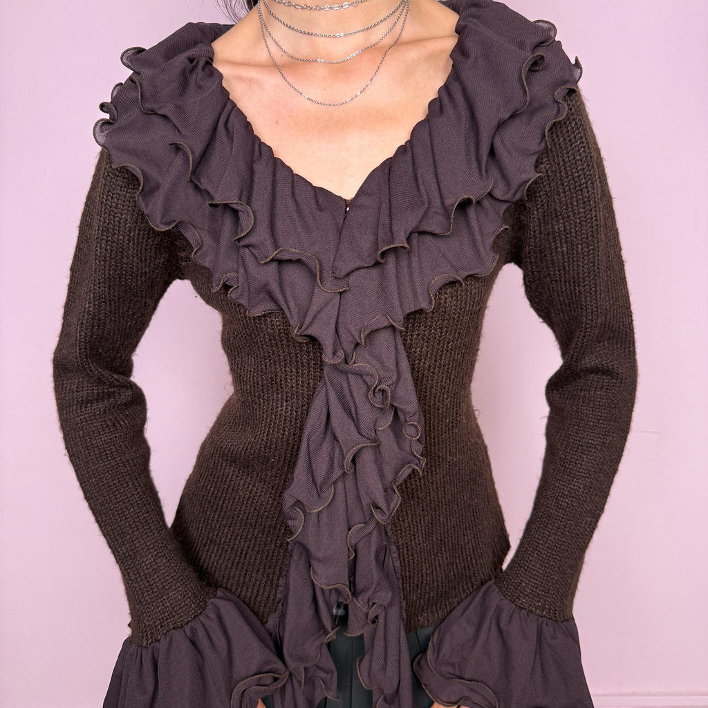 Vintage 2000s dark brown cardigan made from a stretchy knit, featuring dramatic layered mesh ruffles, delicate front buttons, and flared ruffle cuffs. A feminine dark fairy Y2K piece with a romantic statement silhouette. Made from 35% wool, 10% cashmere, and 55% acrylic. Great vintage condition.