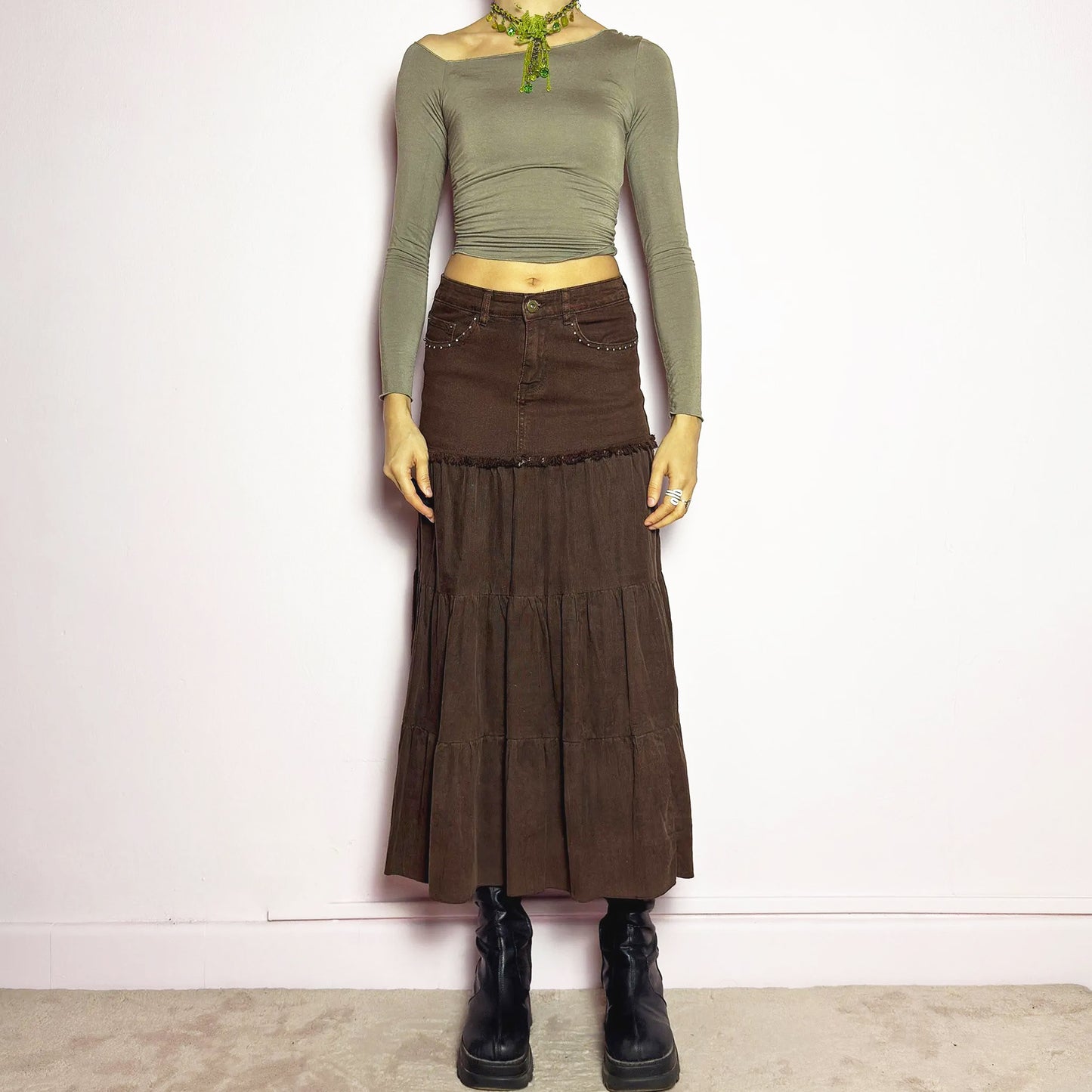 The Y2K Brown Tiered Midi Skirt is a vintage 2000s piece combining denim and soft corduroy for a unique mixed-fabric look. Featuring a stretchy waistband with rhinestone embellishments, pockets and a button-zipper closure, this skirt transitions into flowy tiered corduroy panels for a boho-inspired silhouette. Perfect for casual outfits. Excellent vintage condition.