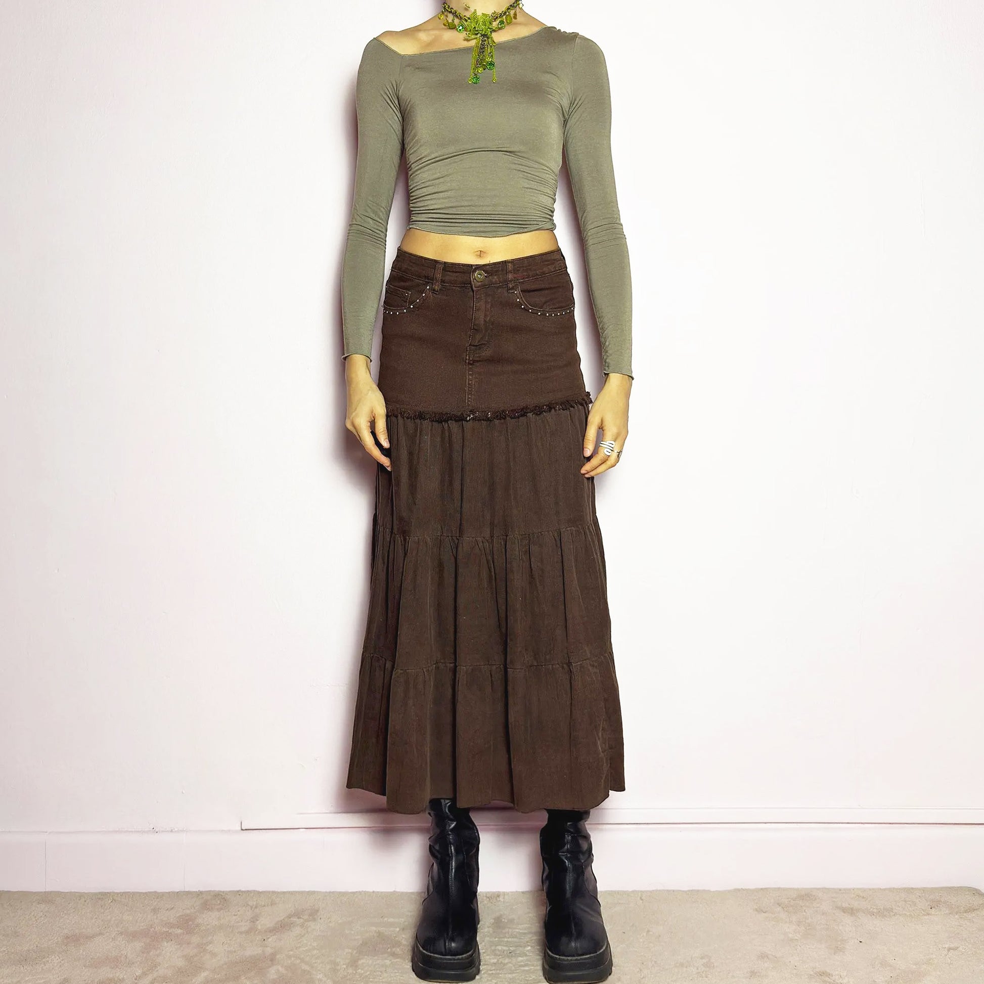 The Y2K Brown Tiered Midi Skirt is a vintage 2000s piece combining denim and soft corduroy for a unique mixed-fabric look. Featuring a stretchy waistband with rhinestone embellishments, pockets and a button-zipper closure, this skirt transitions into flowy tiered corduroy panels for a boho-inspired silhouette. Perfect for casual outfits. Excellent vintage condition.