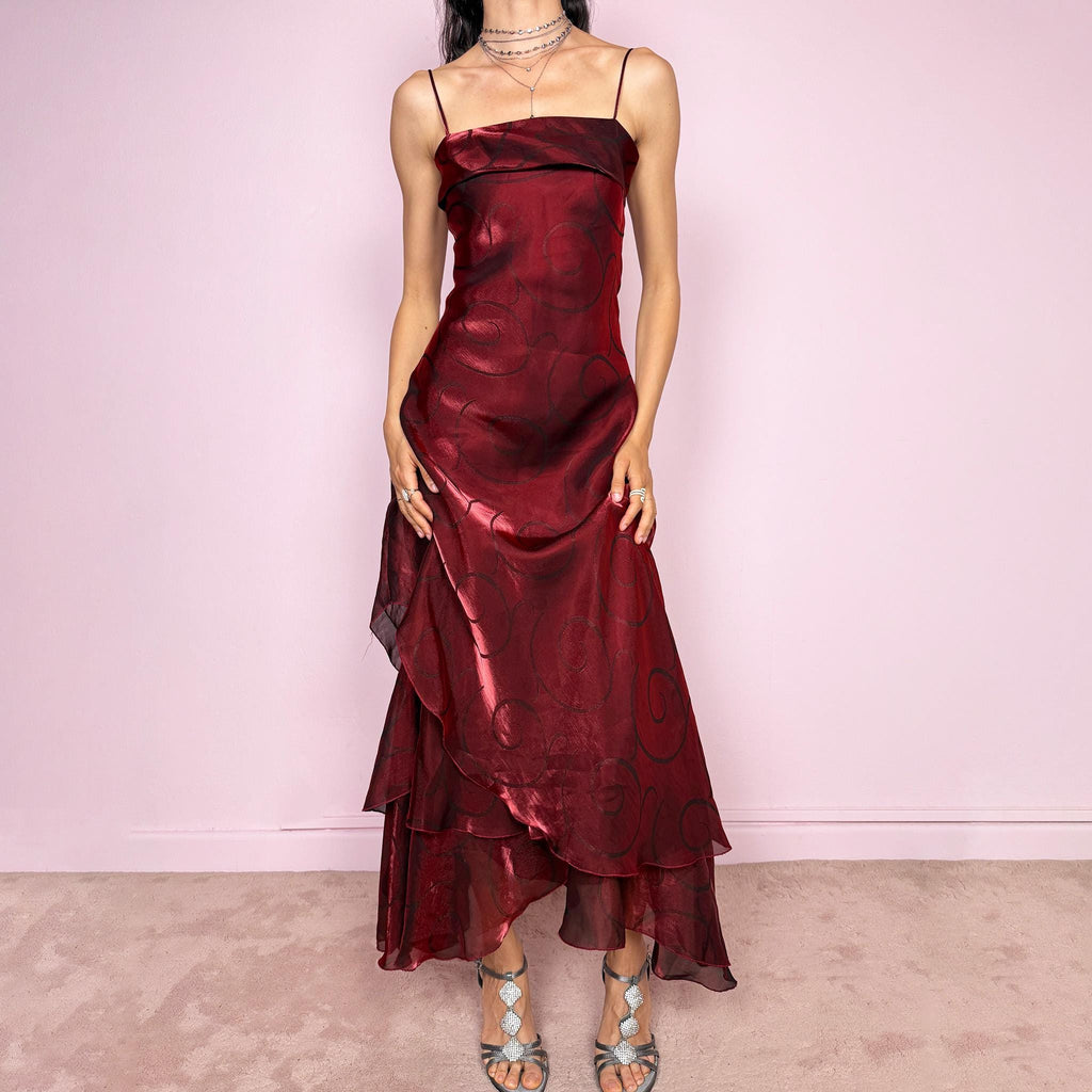 Vintage 2000s statement burgundy midi dress with iridescent shimmer and elegant layered construction. Features spaghetti straps, asymmetrical tiered hem and sheer overlay with swirl pattern. Fluid body-skimming fit with romantic movement, perfect for evening events or occasionwear. Made in France from a polyester elastane blend. Excellent vintage condition.