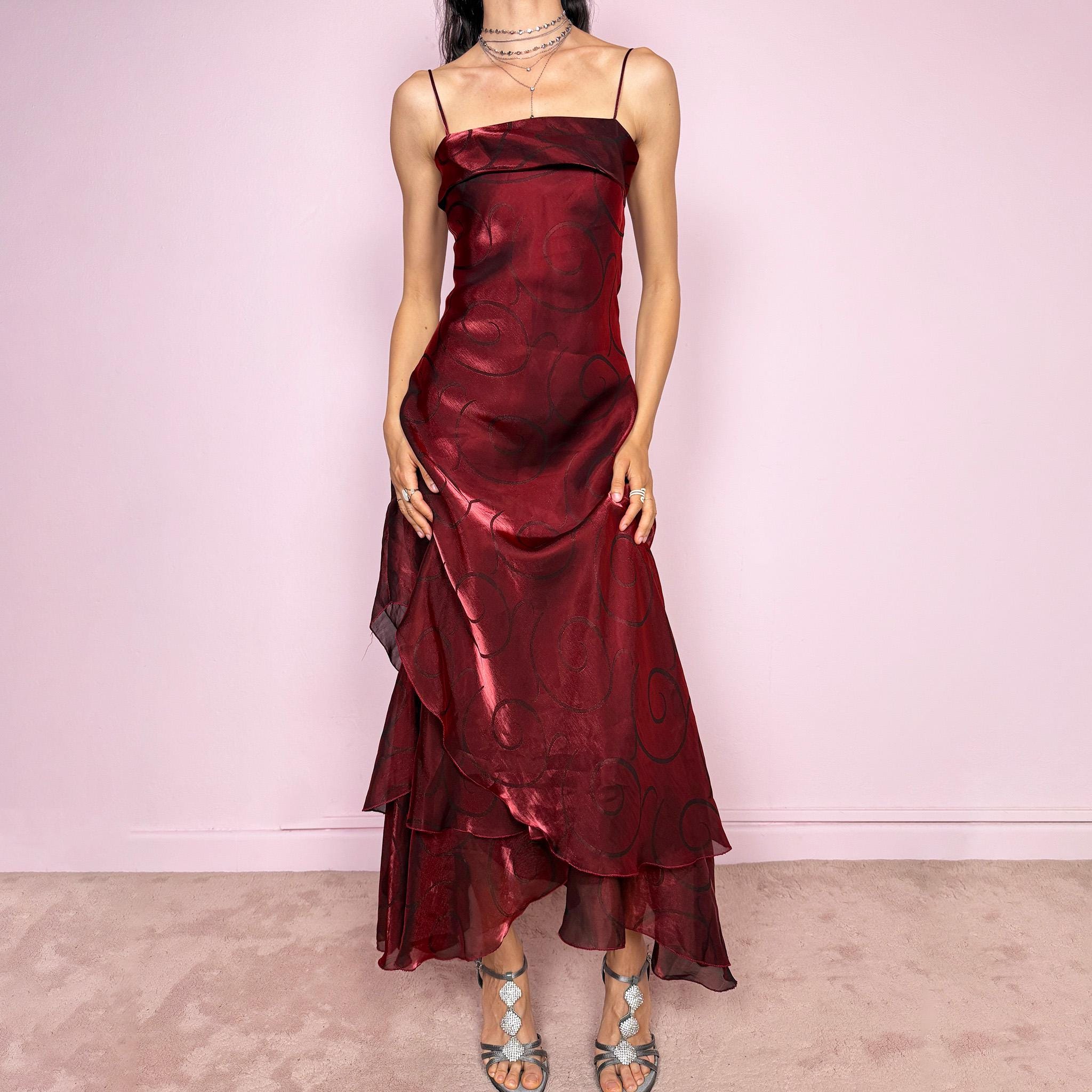 Vintage 2000s statement burgundy midi dress with iridescent shimmer and elegant layered construction. Features spaghetti straps, asymmetrical tiered hem and sheer overlay with swirl pattern. Fluid body-skimming fit with romantic movement, perfect for evening events or occasionwear. Made in France from a polyester elastane blend. Excellent vintage condition.