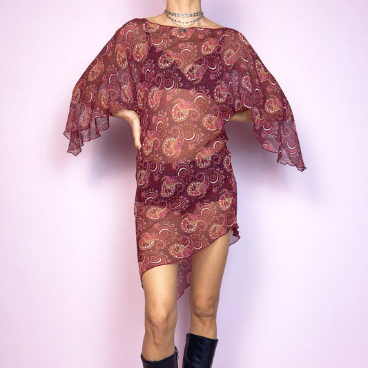 This vintage 2000s mini dress features a sheer burgundy paisley print, wide butterfly sleeves, and an asymmetric hem. Cut from lightweight fabric with no stretch, it drapes fluidly and falls mid-thigh with high side slits. Unlined and semi-transparent, perfect for layering or worn bold. A romantic Y2K silhouette with bohemian and fairycore energy—effortless, floaty, and made for summer nights. Great vintage condition.
