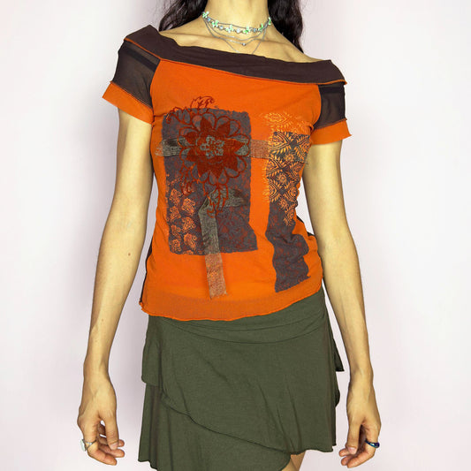 This vintage 2000s mesh top features a rich burnt orange and chocolate colorblock design with floral patchwork motifs. Designed with short sleeves, an off-the-shoulder neckline, and semi-sheer mesh accents, this fitted piece evokes bold, bohemian energy. A rare deconstructed artistic find from the Y2K era, perfect for statement dressing with a warm palette. Made of polyester blend. Excellent vintage condition.