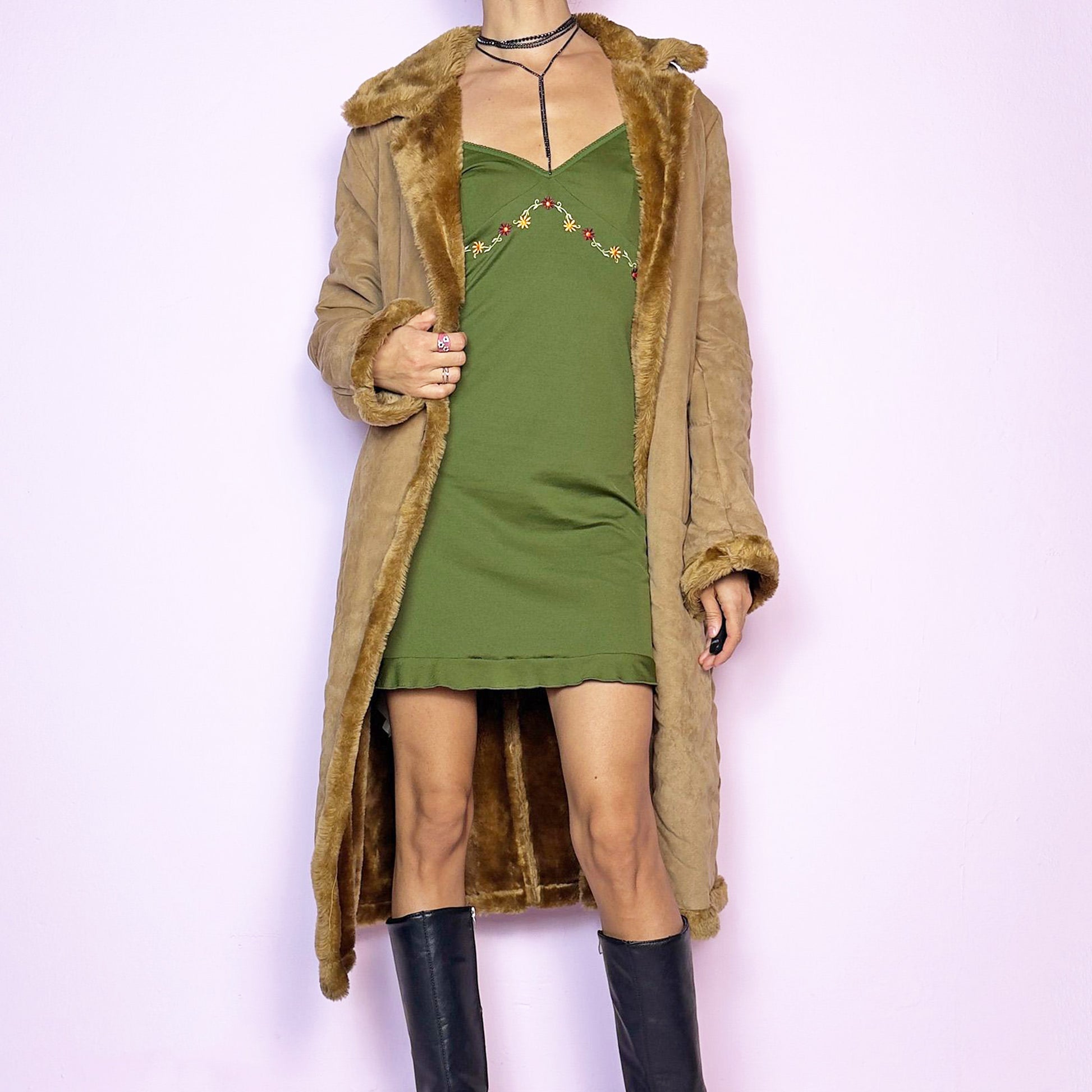 The Y2K Faux Suede Maxi Coat is a vintage 2000s cozy piece featuring a classic camel-tone faux suede exterior accented with plush faux fur trim along the collar, cuffs, and hem. This longline coat includes button-front closures and a tailored fit, offering warmth and is ideal for winter outings or elegant casual wear. Great vintage condition.