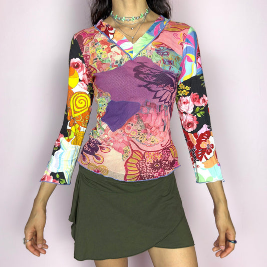 The Y2K Art Mesh Top is a vintage 2000s piece with a psychedelic explosion of painterly prints in vibrant pinks, reds, yellows, and blues. Crafted from semi-sheer mesh, it features a V-neckline and three quarter sleeves. The lightweight stretch fit makes it perfect for festivals, rave nights, or any bold summer moment. A wearable art statement with chaotic elegance and Y2K maximalist energy.