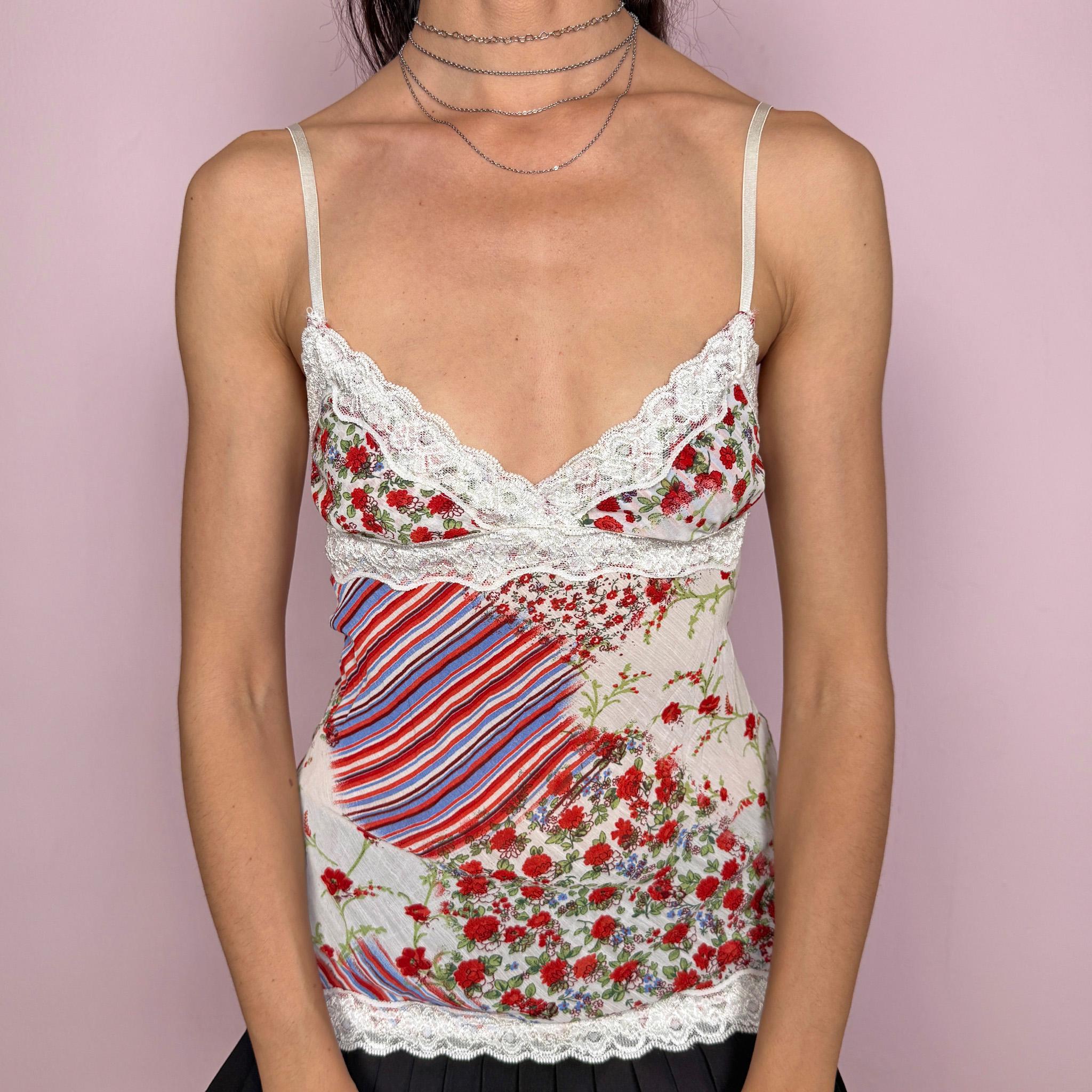 Vintage 2000s floral cami top in cream with a red floral patchwork print, and a feminine fitted silhouette. Features adjustable straps, a flattering V neckline, white lace trim along the bust and hem, and a tie-back closure for an adjustable fit. Lightweight and soft, with a romantic Y2K bohemian/summer fairy feel for elevated summer looks. Made in Italy from 100% viscose. Excellent vintage condition.
