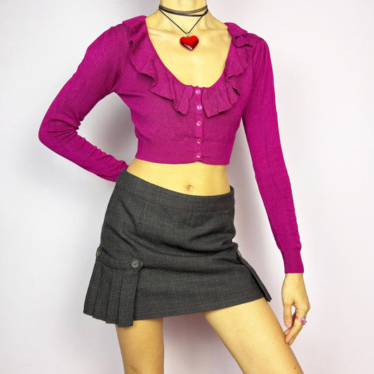 The Y2K Dark Brown Plaid Mini Skirt is a vintage 2000s piece featuring decorative button with pleated panel details on each side. Made from a thick woven fabric with a subtle plaid pattern, it has a side zipper closure. Perfect for preppy, or casual winter outfits.
