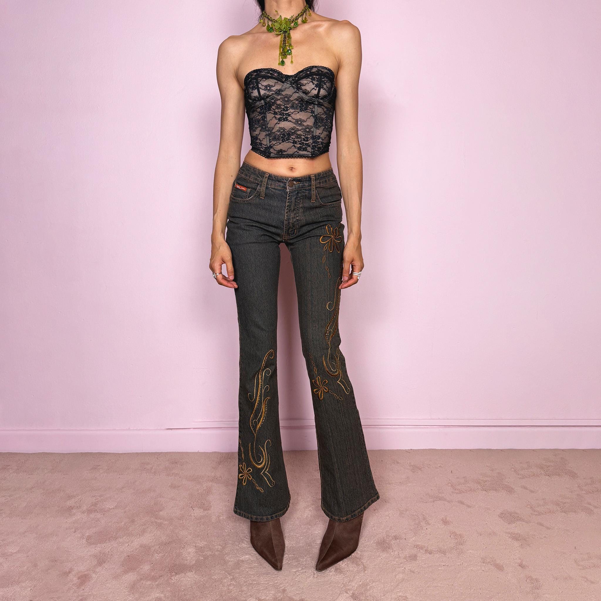 Vintage 2000s dark wash flared jeans with a mid-rise fit and bronze floral embroidery along the legs. Designed in slightly stretchy denim fabric. The embroidered floral details give the jeans a strong Y2K western and bohemian feel. Excellent vintage condition.