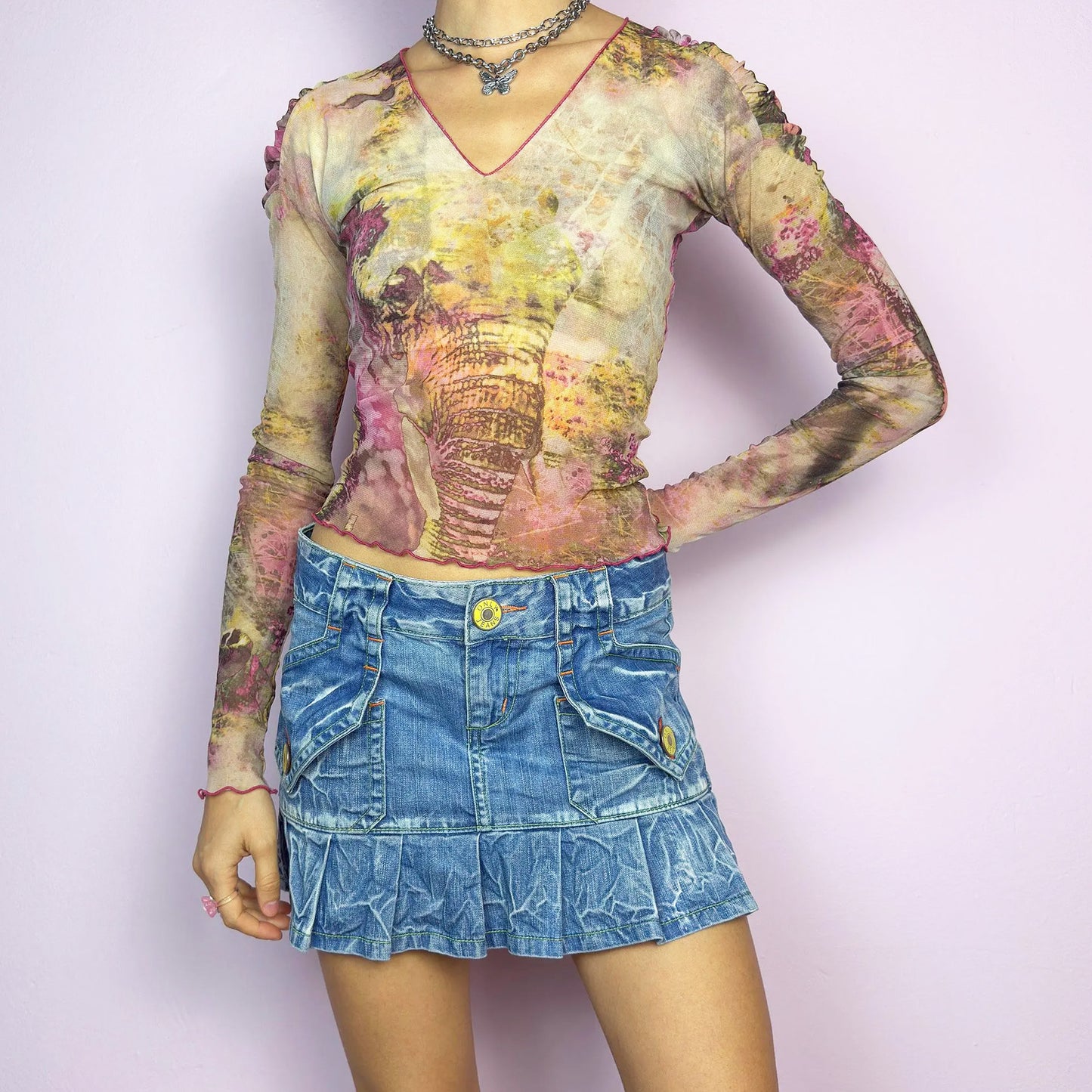 The Y2K Pleated Mini Denim Skirt is a vintage 2000s piece featuring a pleated hem and cargo-style pockets with button details for a playful, utilitarian touch. Crafted from washed blue denim with contrast stitching, this low-rise mini has a button and zipper closure. Perfect for casual, streetwear, or festival looks. Great vintage condition.