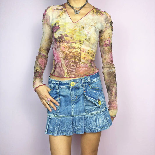 The Y2K Pleated Mini Denim Skirt is a vintage 2000s piece featuring a pleated hem and cargo-style pockets with button details for a playful, utilitarian touch. Crafted from washed blue denim with contrast stitching, this low-rise mini has a button and zipper closure. Perfect for casual, streetwear, or festival looks.