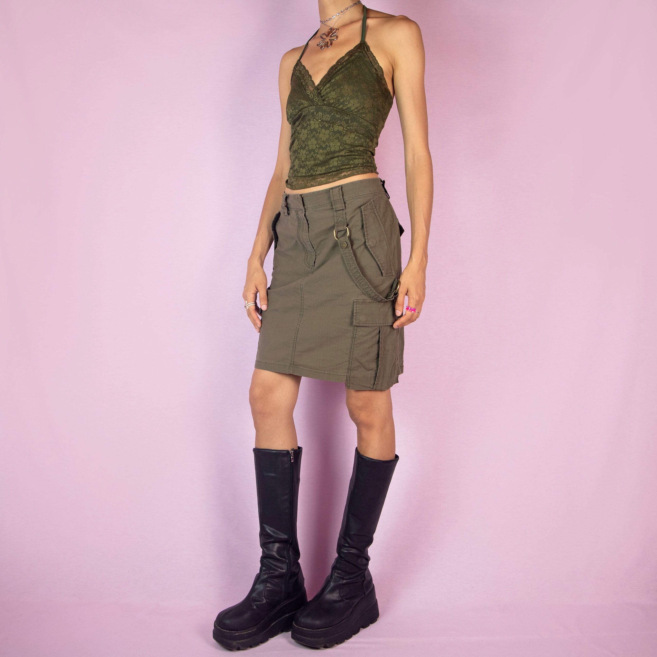 This vintage 2000s Diesel cargo skirt features a military-inspired design in khaki green with multiple pockets, belt loops, and a front zipper closure. Its structured silhouette and utilitarian details capture Y2K gorpcore and grunge deconstructed style, perfect for city streetwear layering. A collectible Diesel archive piece balancing function with edgy fashion. Made from a cotton blend woven fabric. Excellent vintage condition.
