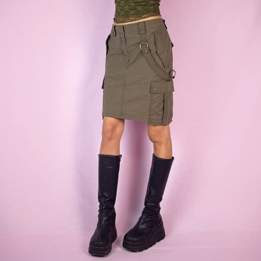 This vintage 2000s Diesel cargo skirt features a military-inspired design in khaki green with multiple pockets, belt loops, and a front zipper closure. Its structured silhouette and utilitarian details capture Y2K gorpcore and grunge deconstructed style, perfect for city streetwear layering. A collectible Diesel archive piece balancing function with edgy fashion. Made from a cotton blend woven fabric. Excellent vintage condition.
