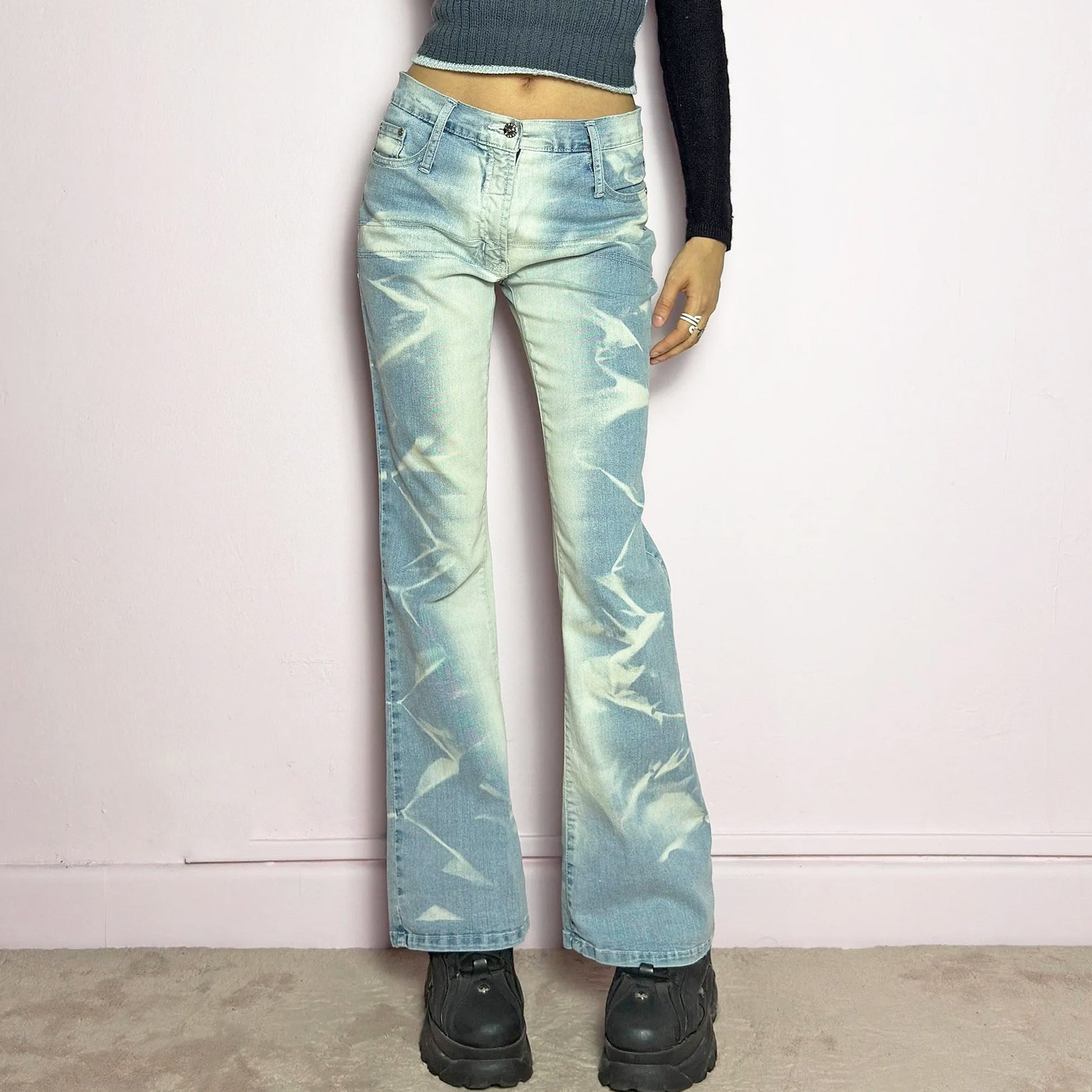 The Y2K Bleached Flare Jeans are a vintage 2000s statement piece featuring a light-wash denim with a bold bleached abstract pattern for a deconstructed, experimental look. Designed with a flattering mid-rise fit, flared legs, button and zipper closure, and pockets, these jeans are a perfect blend of edgy and playful aesthetics. Ideal for standout casual outfits.