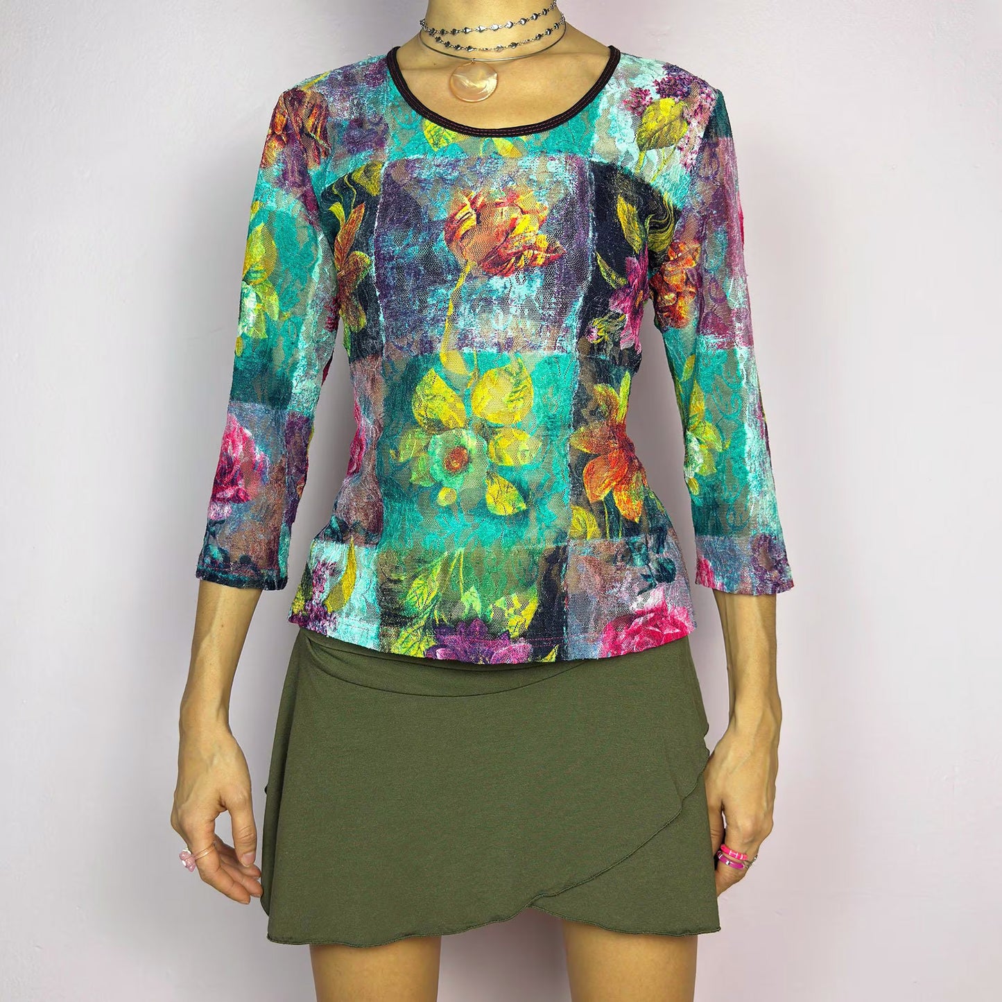 The Y2K Painting Lace Mesh Top is a vintage 2000s artistic statement piece. Featuring a semi-sheer lace fabric adorned with a bold, vibrant floral pattern resembling a painterly masterpiece, a scoop neckline and 3/4 sleeves. Perfect for layering in spring or summer. Excellent vintage condition.